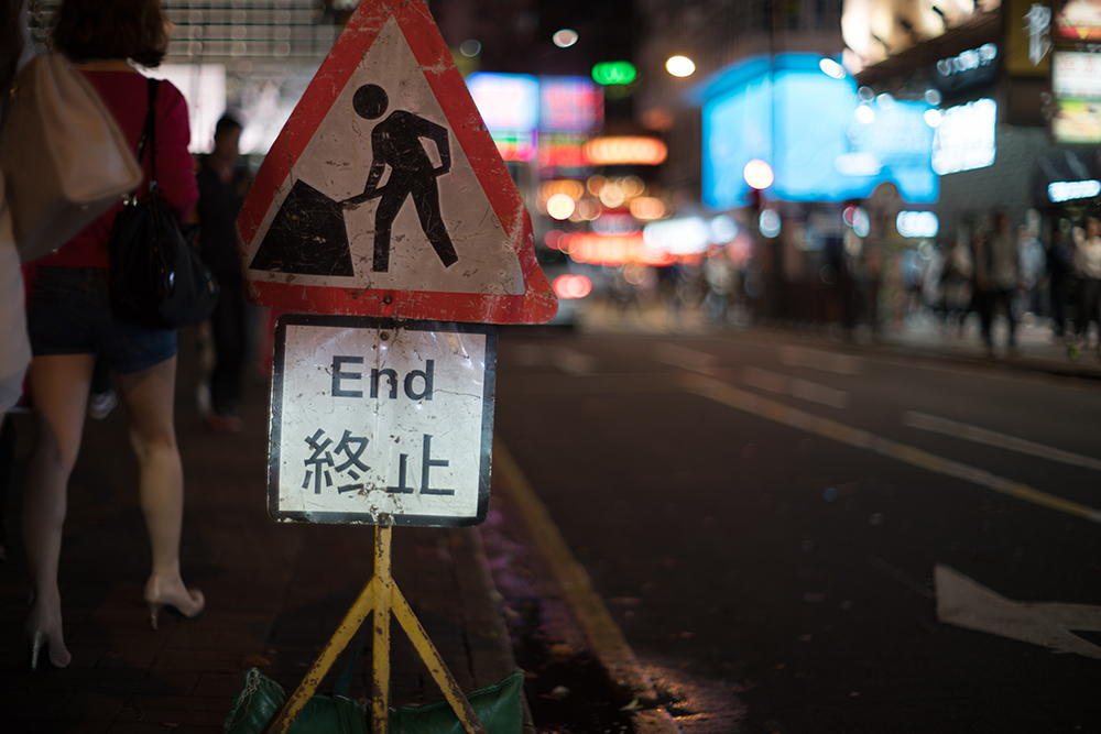 α7II + Kistar 55mm F1.2 絞り優先AE F1.2 1/60秒 -0.7EV ISO100 AWB RAW 工事の標識にヘッドライトが当たった瞬間を狙った。標識だけが浮かび上がり、背景は大きくボケる。ランダムに浮かぶ玉ボケがおもしろい。