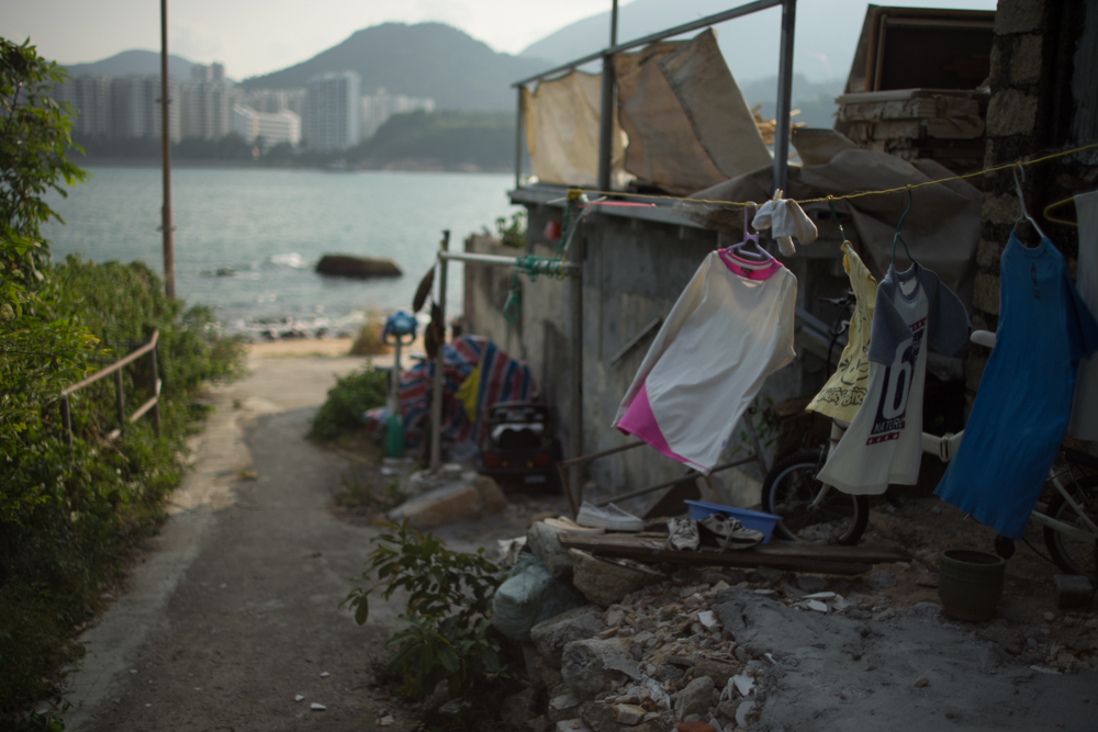 α7II + Kistar 35mm F1.4　絞り優先AE　F1.4　1/8000秒　-1.3EV　ISO100　AWB　RAW　風にゆれるTシャツに、すばやく開放でピントを合わせた。被写体だけで空間から浮かび上がり、海へつづく道は大きくボケる。